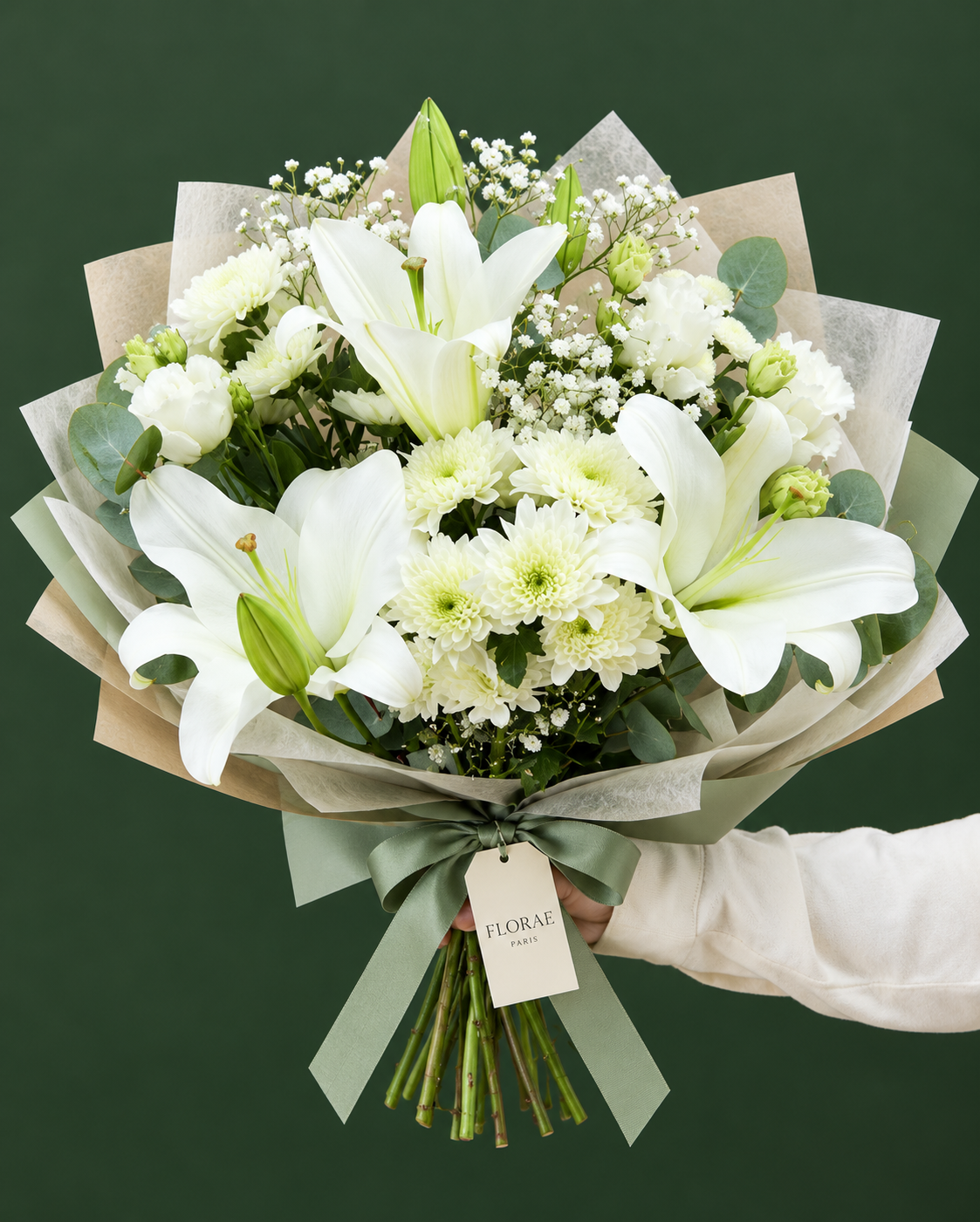 Lumière Blanche — Lys blancs, lisianthus blancs, chrysanthèmes blancs, gypsophile et eucalyptus. Bouquet Florae sur fond vert.